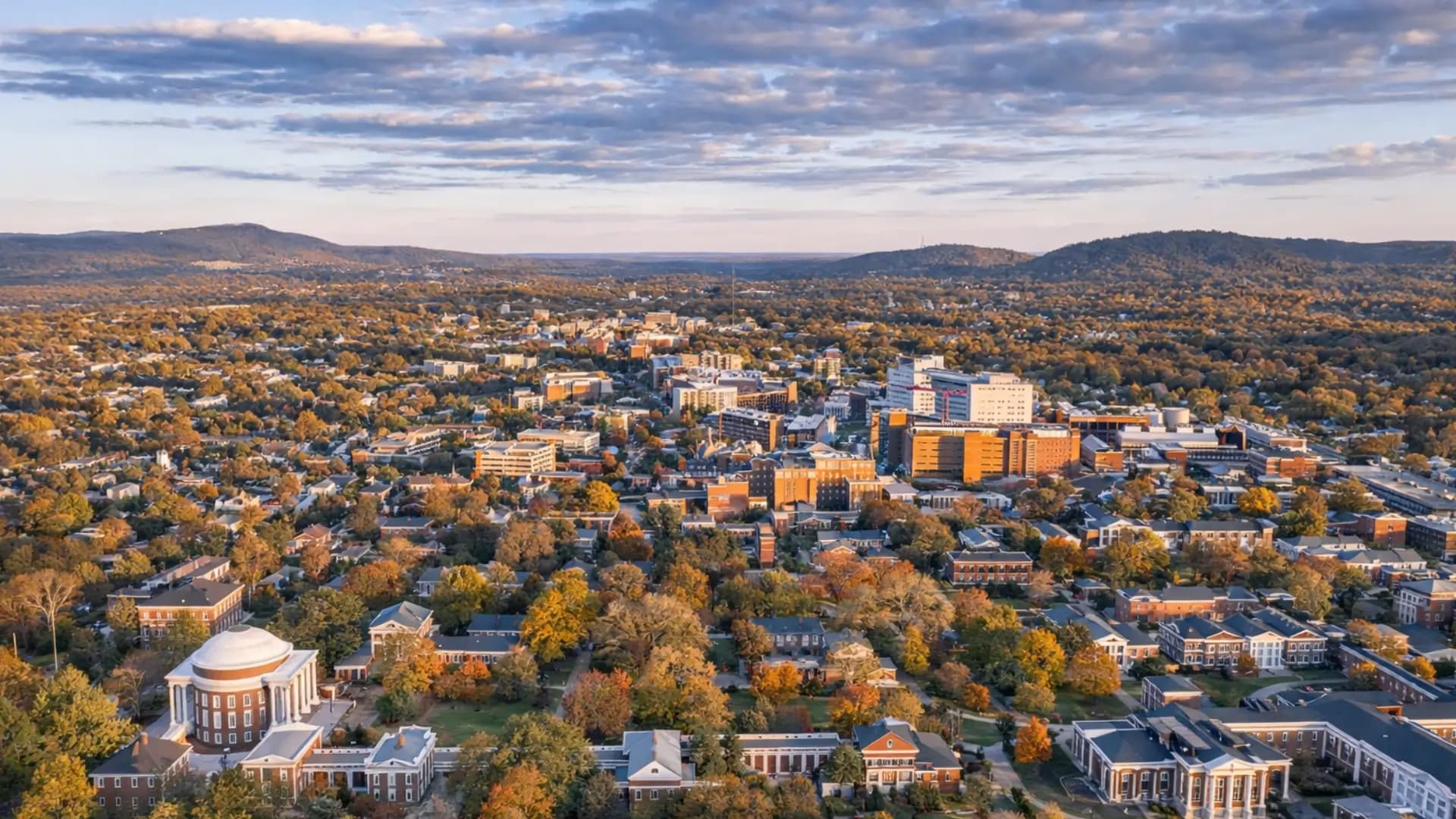 Aerial view of Charlottesville, Virginia with the University of Virginia Rotunda and Blue Ridge Mountains in autumn