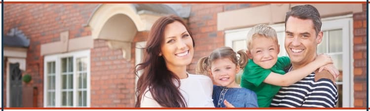 A happy family stand outside their home that is free of environmental contamination