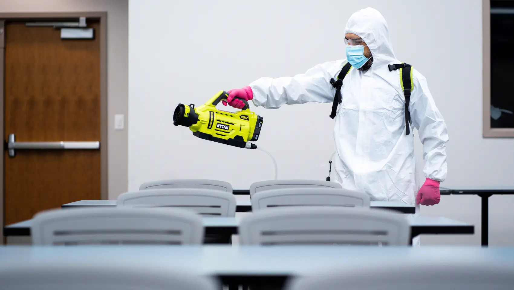 Technician wearing protective equipment performing controlled environmental remediation